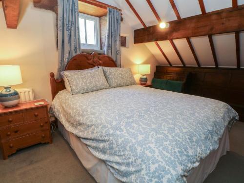 a bedroom with a bed with a blue comforter at Pearls Farm One in Macclesfield