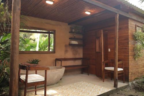 a bathroom with a tub and two chairs and a window at Costeño Beach in Santa Marta