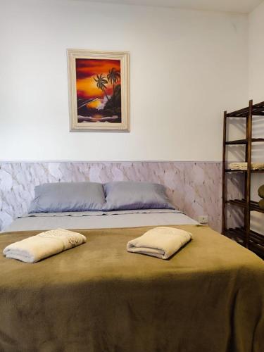 a bed with two pillows on top of it at Pousada Espaço Vista Mar in Itanhaém
