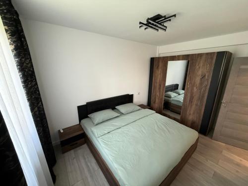 a small bedroom with a bed and a mirror at Anais Flower in Târgu Neamț