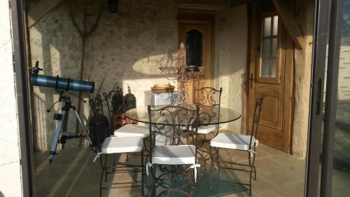 une table en verre et des chaises dans une pièce avec une caméra dans l'établissement bastide de beauvallon, à Fourcès