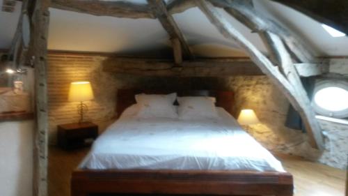 une chambre avec un grand lit dans un mur de pierre dans l'établissement bastide de beauvallon, à Fourcès