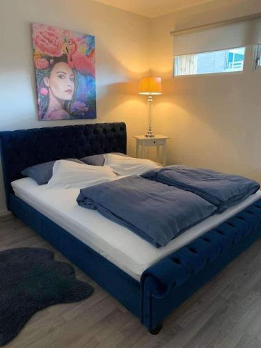 a bed in a bedroom with a painting on the wall at SylviaBo i Skien sentrum in Skien