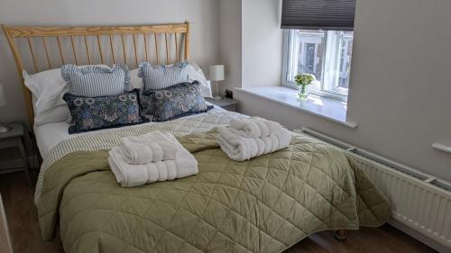 a bedroom with a bed with towels on it at Troopers Cottage in Frome