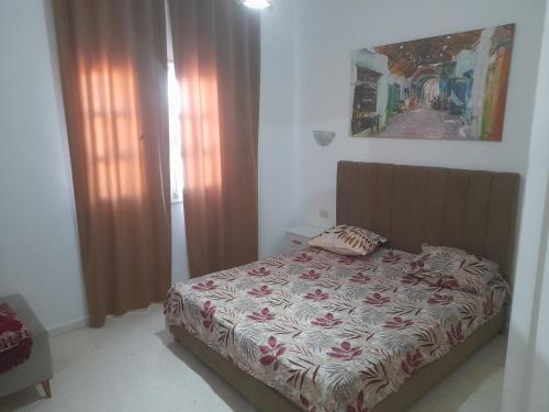 a bedroom with a bed and a picture on the wall at Taguermess Tag 1 in Midoun