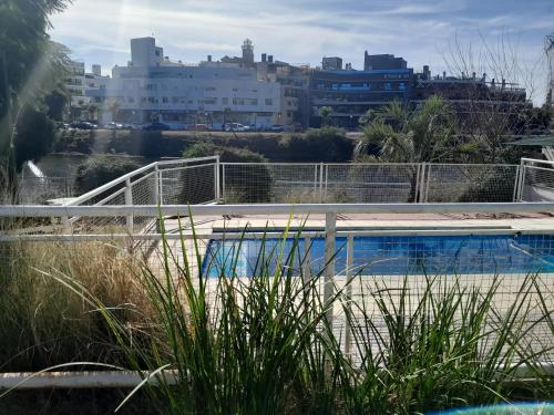 a swimming pool with a city in the background at CRISTAL BuenaVista in Villa Carlos Paz