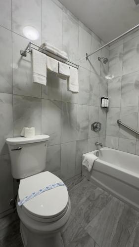 ein Badezimmer mit Toilette und Badewanne in der Unterkunft Town Centre Inn - Parry Sound in Parry Sound