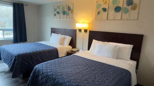 ein Hotelzimmer mit zwei Betten und einem Fenster in der Unterkunft Town Centre Inn - Parry Sound in Parry Sound