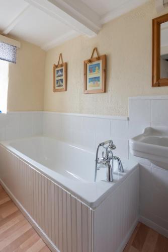 a bathroom with a tub and a sink at Courtyard Farm Cottages in Boscastle