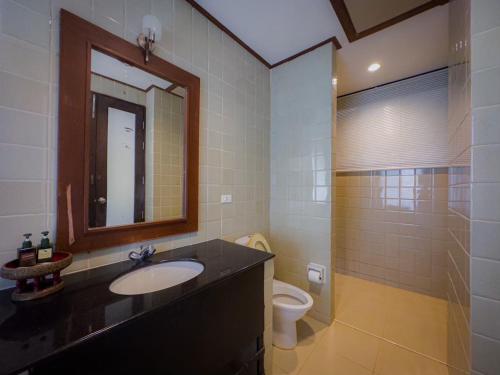 a bathroom with a sink and a toilet and a mirror at Kooncharaburi Resort - Koh Chang in Ko Chang