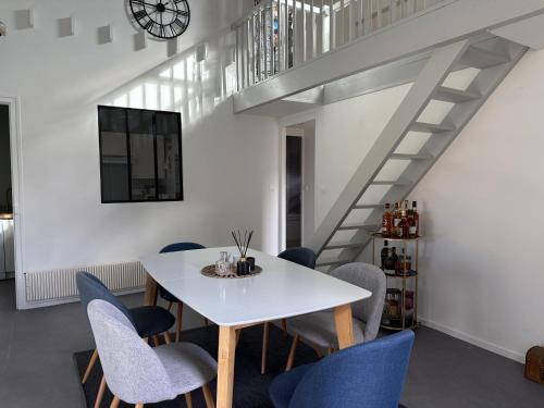 a dining room with a white table and blue chairs at La Maisonnette de Fontaine - Au calme avec jardin in Fontaine-sous-Jouy