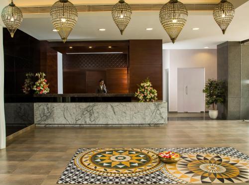 a lobby with a reception desk and a table at The Raviz Calicut in Kozhikode