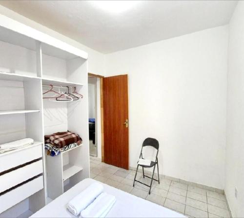 a bedroom with a bed and a chair in it at Hospedagem Aeroporto in Campinas