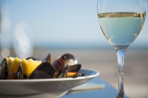 a glass of wine next to a plate of food at Hostal Boutique Casa del Mar Altea in Altea