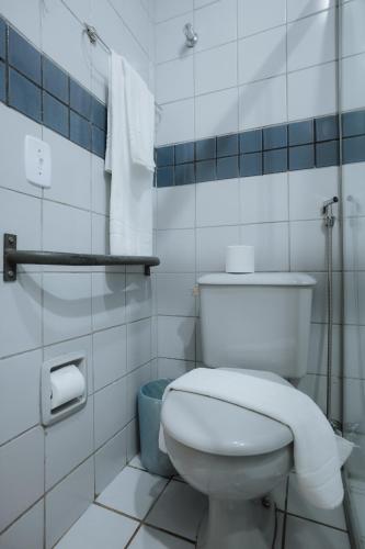 a white bathroom with a toilet and a blue basket at Hotel Nacional Service - Fácil acesso a Região da 44 e Rodoviária in Goiânia