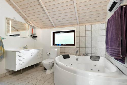 a white bathroom with a tub and a toilet at LF16031-Farso-Spydspidsevej-31 in Ertebølle
