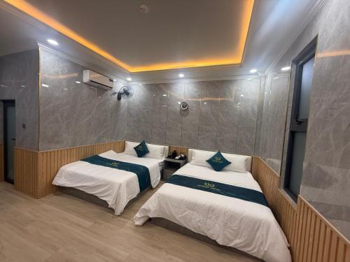 a room with two beds in a room at Victory Hotel in Xóm Hương Phùng