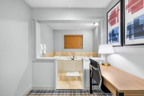 a bathroom with a desk and a sink at AmericInn by Wyndham Delafield-Milwaukee in Delafield
