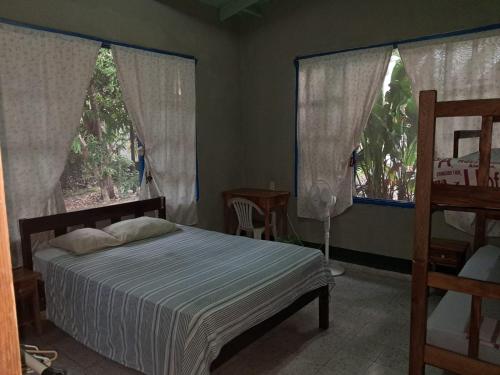 a bedroom with a bed and two large windows at Overlooking Budget Hotel in San Pedro Sula