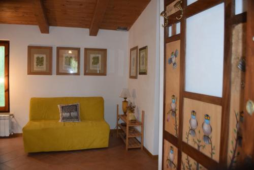 a living room with a yellow couch in a room at Camporegio in Civitella Cesi