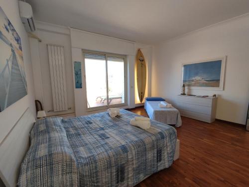 a bedroom with a large bed and a window at LightHouse - Surfandwindsurferhouse in Anzio