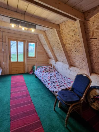 a bedroom with a bed and a chair in a attic at Auto kamp Runolist in Rožaje