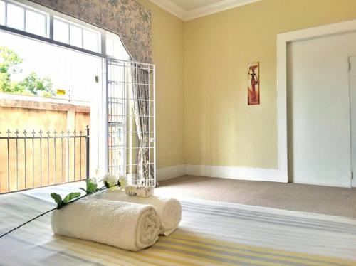 a room with a large window and a pillow on the floor at Versailles in Pretoria