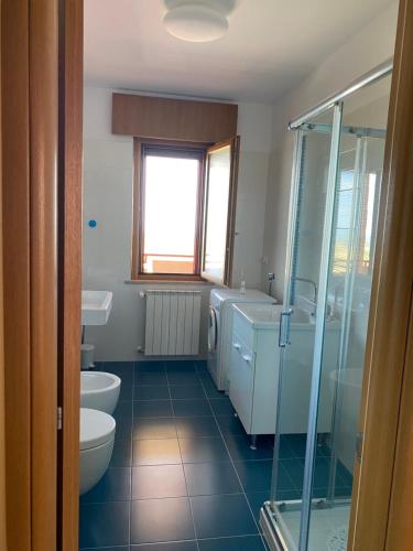 a bathroom with two sinks a toilet and a shower at La casa di John in Guglionesi