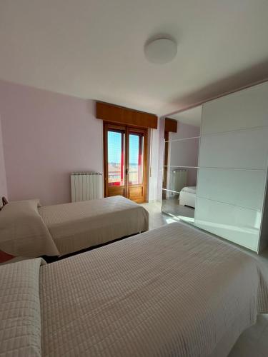 a hotel room with two beds and a window at La casa di John in Guglionesi