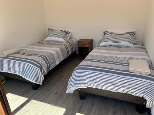 two twin beds in a room with at Tiny House en parcela de Puerto Varas in Puerto Varas