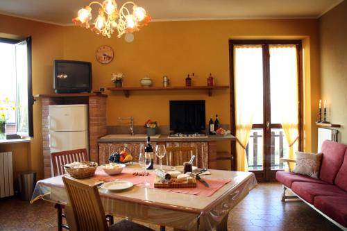Il comprend un salon avec une table et une cuisine. dans l'établissement La Casa Dei Ricordi, à Castino