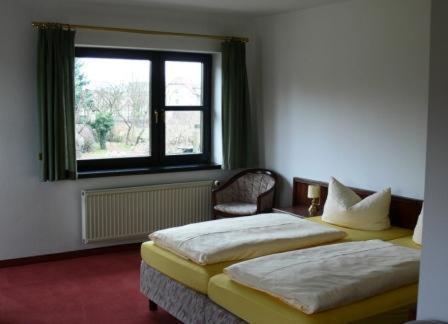 two twin beds in a room with a window at Hotel Landhaus Moritzburg in Moritzburg