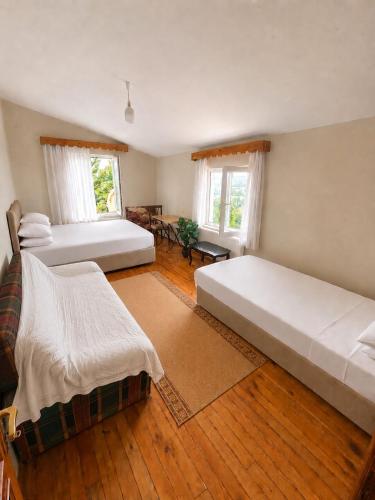 a large bedroom with two beds and wooden floors at Nature Gate Airport Hotel in Arnavutköy