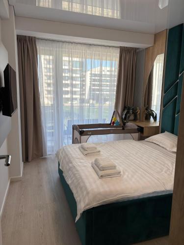 a bedroom with a large bed and a window at TheBlueEscape Apartment in Năvodari