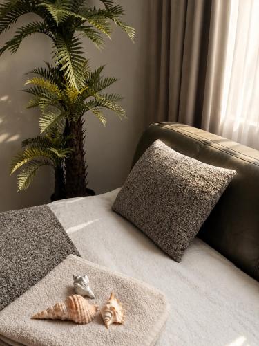 a bed with a pillow and a palm tree at Central Apartment Facing the Cathedral in Chişinău