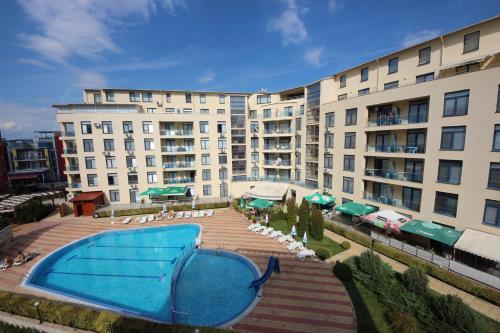 - un grand bâtiment avec une piscine en face dans l'établissement Rainbow 4 - Menada Apartments, à Sunny Beach