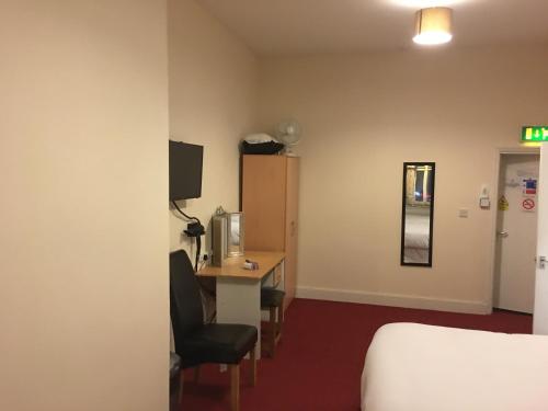 a hotel room with a bed and a desk and a bed at ML Lodge in Cardiff
