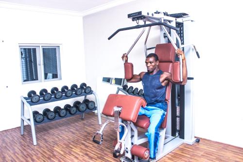 a man sitting in a gym on a exercise bike at Visa Karena Hotels in Port Harcourt