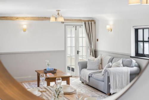 a living room with a couch and a table at Five Acres Cottage in Rickmansworth