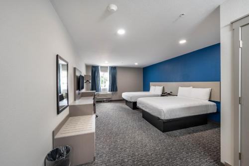 a hotel room with two beds and a blue wall at Hummingbird Hotel in Goodlettsville