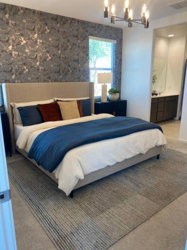 a bedroom with a large bed with blue sheets and pillows at Clark's Luxury Apartment in Phoenix
