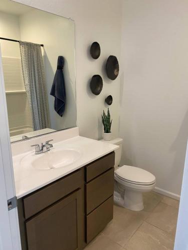 a bathroom with a sink and a toilet and a mirror at Clark's Luxury Apartment in Phoenix