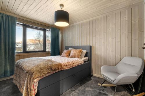 a bedroom with a bed and a chair at Large modern cabin from 2023 for rent in Dirdal