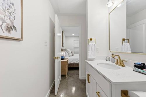 a white bathroom with a sink and a mirror at Decantur Inn 3 King Bedrooms in Lafayette
