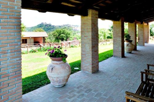 a large vase with flowers in it on a patio at AgriResort Spa Glamping Poggio Di Montedoro in Montefiascone