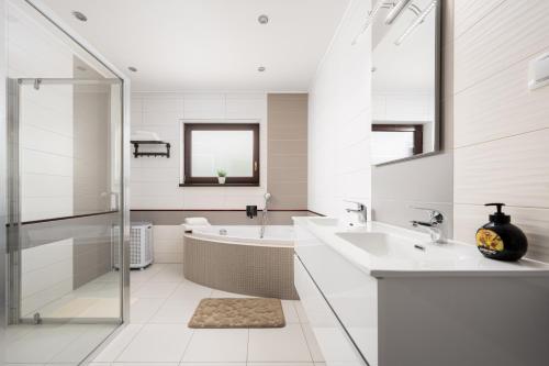 a white bathroom with a tub and a sink at Dům Pavlov in Pavlov
