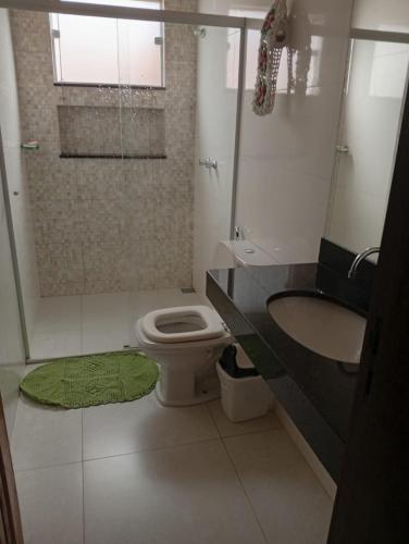 a bathroom with a shower and a toilet and a sink at Casa da Helenice in São Roque de Minas