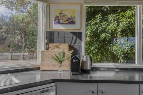 a kitchen with two windows and a counter top at The Ridge House Panoramic views in Aireys Inlet