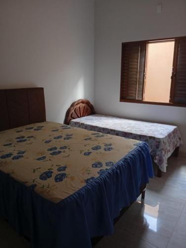 a room with two beds and a window at Casa da Helenice in São Roque de Minas