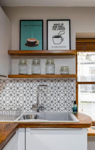 a kitchen counter with a sink and two shelves at Pear Tree Cottage, Dunblane in Dunblane
